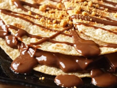 S'mores quesadilla wedges pulled apart, stretching strings of toasted marshmallow and melted milk chocolate with graham