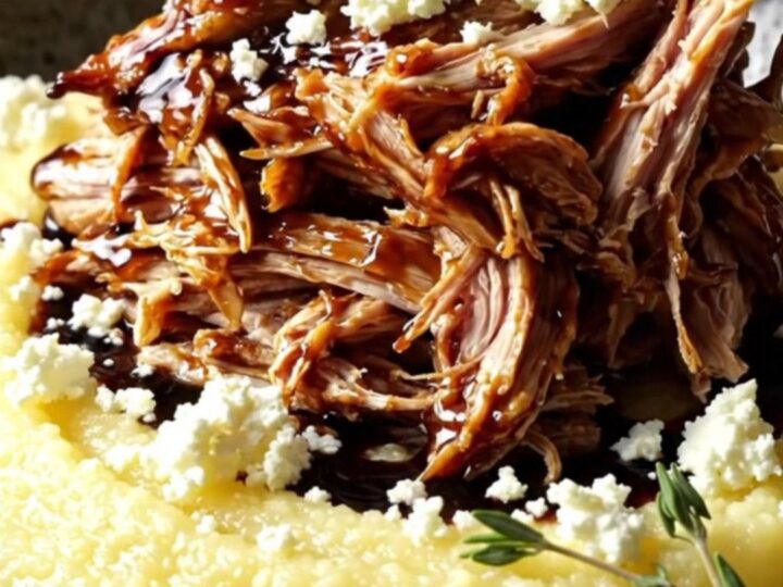 Shredded balsamic fig chicken glazed dark and jammy, spooned over creamy polenta with crumbled goat cheese and thyme