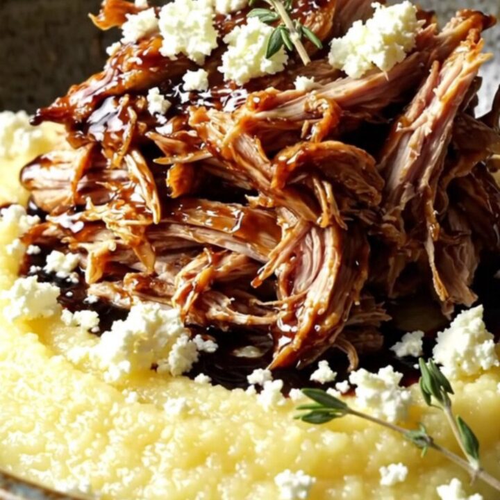 Shredded balsamic fig chicken glazed dark and jammy, spooned over creamy polenta with crumbled goat cheese and thyme