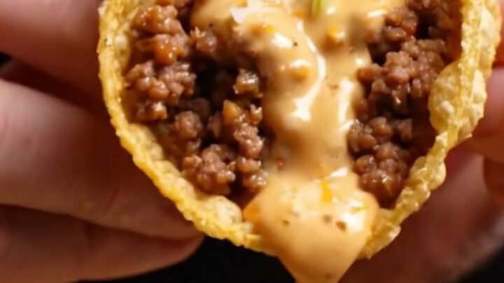Cheesy gordita crunch copycat pulled apart showing melted cheese glue around a crispy taco shell with spiced beef