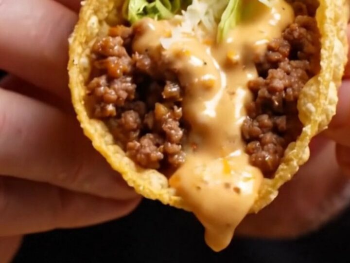 Cheesy gordita crunch copycat pulled apart showing melted cheese glue around a crispy taco shell with spiced beef