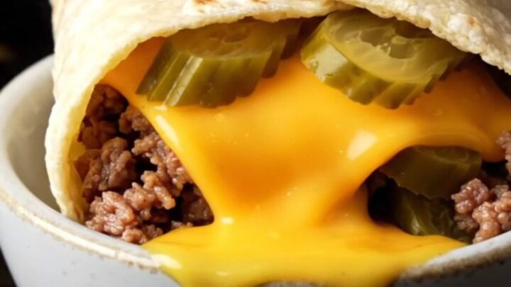 Crispy smash cheeseburger wrap sliced in half with melted cheddar and juicy beef