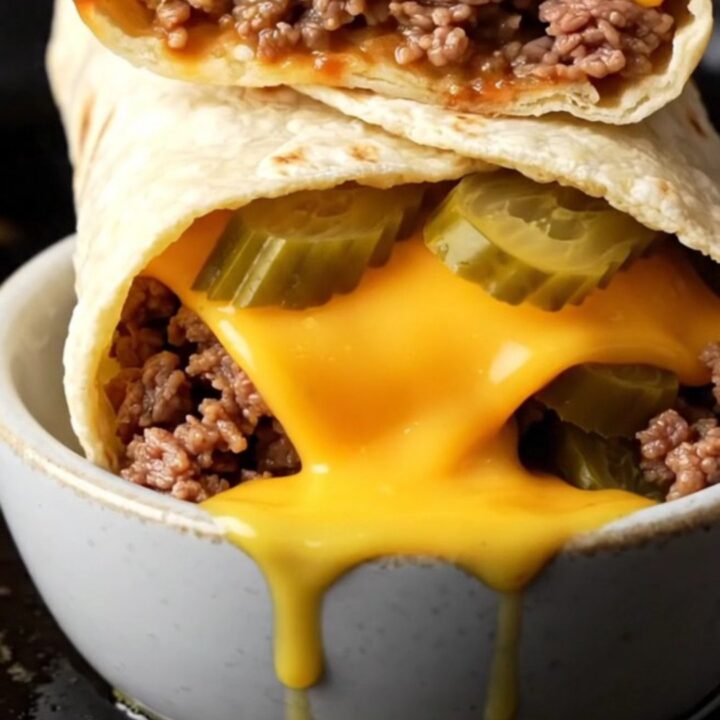 Crispy smash cheeseburger wrap sliced in half with melted cheddar and juicy beef