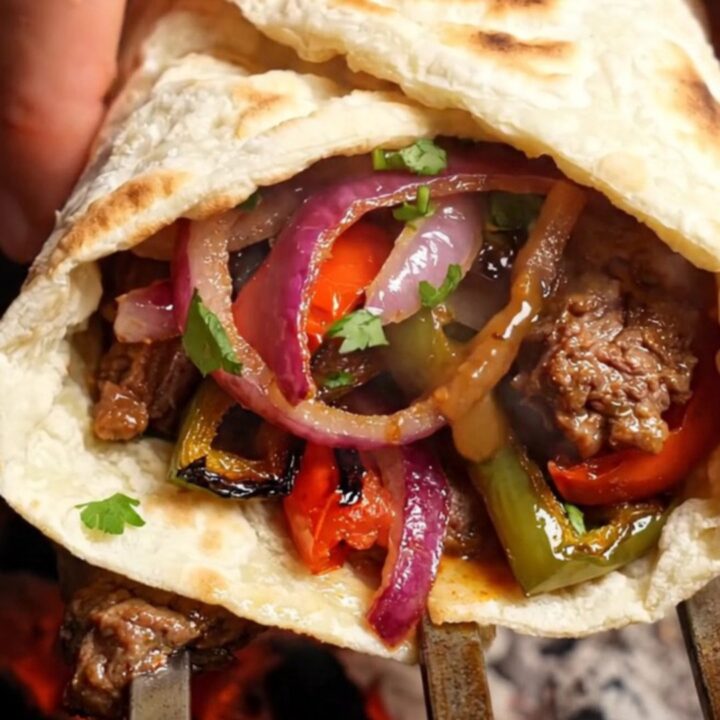 Crispy Turkish Adana kebab wrap sliced in half, showing juicy meat and colorful vegetables