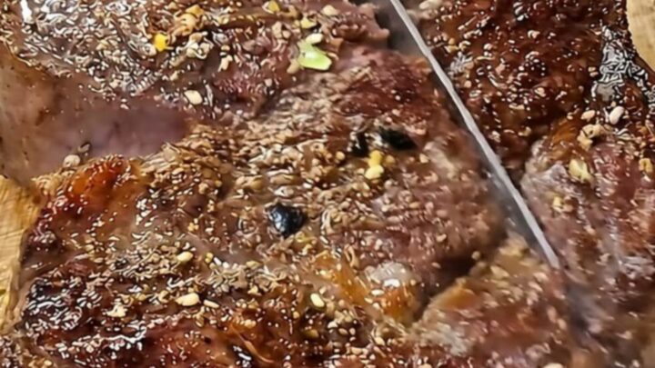 A perfectly cooked tomahawk steak with a golden brown crust resting on a rustic wooden board.