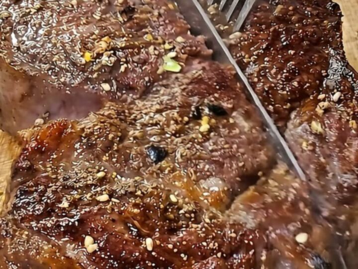 A perfectly cooked tomahawk steak with a golden brown crust resting on a rustic wooden board.