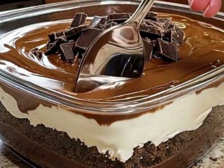 Dessert au chocolat en couches dans un plat carré en verre, nappage brillant et éclats de chocolat
