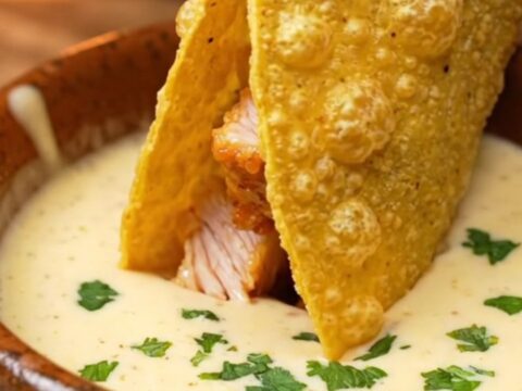 Crispy chicken Alfredo tacos with melted mozzarella and dipping sauce on a plate