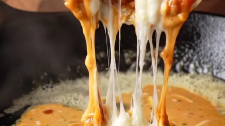 Crispy chipotle chicken wrap sliced in half, showing juicy chicken and melted cheese with creamy sauce on the side