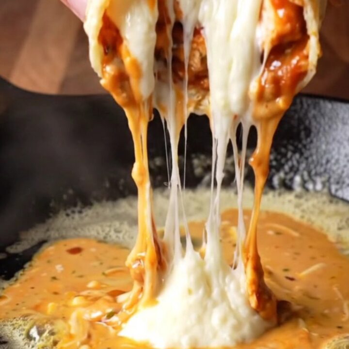 Crispy chipotle chicken wrap sliced in half, showing juicy chicken and melted cheese with creamy sauce on the side