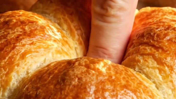 Golden flower-shaped brioche buns with chocolate filling, pulled apart on a baking sheet