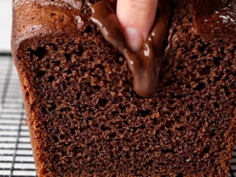 Sliced double chocolate banana bread on a cooling rack, showing moist fudgy interior with melted chocolate chips.