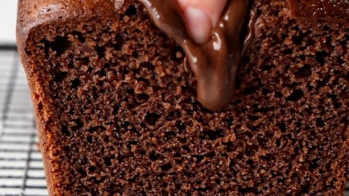 Sliced double chocolate banana bread on a cooling rack, showing moist fudgy interior with melted chocolate chips.