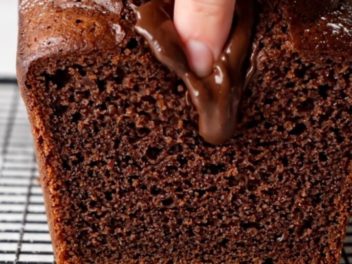Sliced double chocolate banana bread on a cooling rack, showing moist fudgy interior with melted chocolate chips.