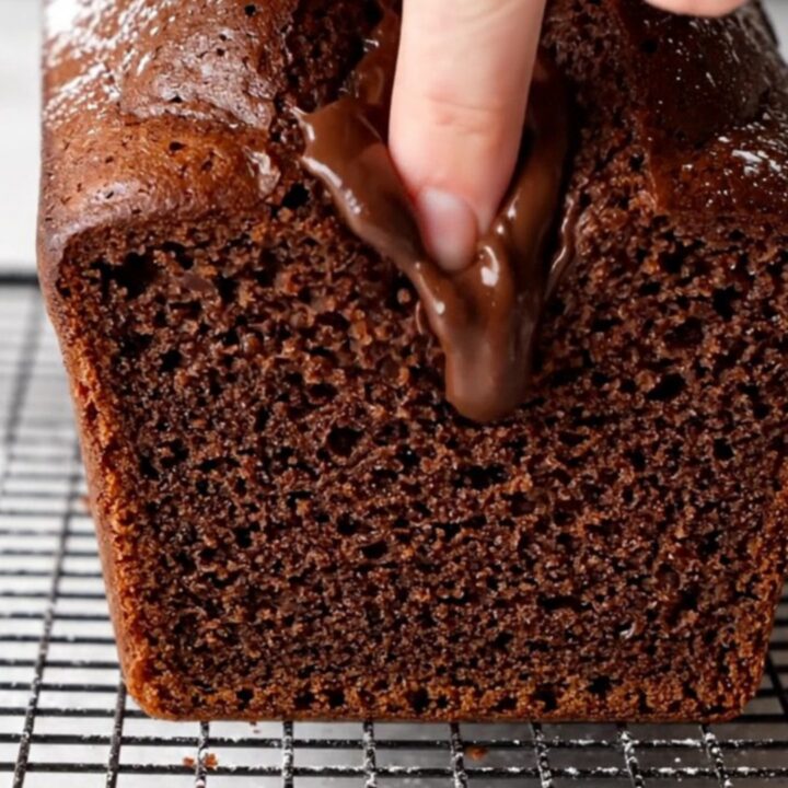 Sliced double chocolate banana bread on a cooling rack, showing moist fudgy interior with melted chocolate chips.