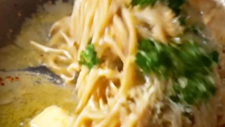 Twirled spaghetti coated in caramelized onion garlic butter sauce with parmesan and parsley