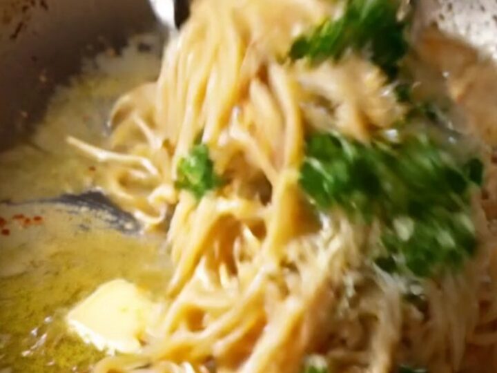 Twirled spaghetti coated in caramelized onion garlic butter sauce with parmesan and parsley