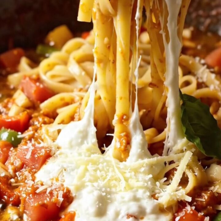 Tagliatelle pasta with roasted tomatoes and peppers, topped with melted mozzarella and basil