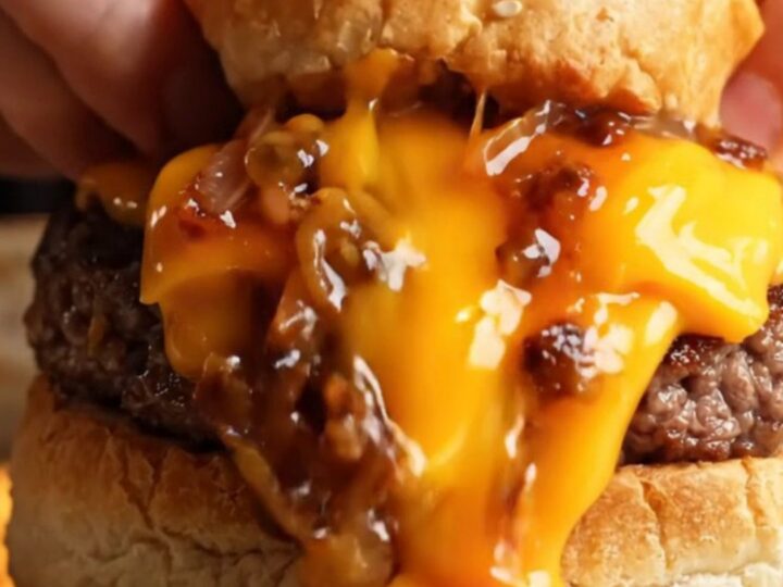 Sealed stuffed cheeseburger cut open showing melted cheese and juicy beef inside golden dough