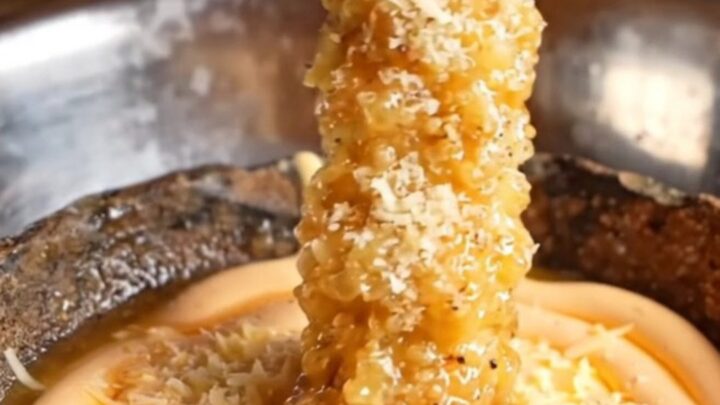 Giant golden crispy extra-long fries piled on a plate with a bowl of spicy mayo