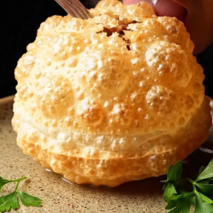 Golden brown çi börek hand pies puffed like balloons on a wire rack