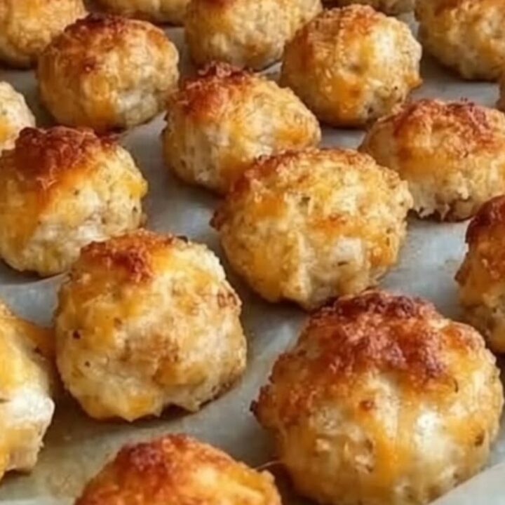 Bouchées au fromage dorées sur une plaque, l'une ouverte révélant un cœur filant et fumant