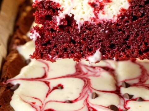 Red velvet cheesecake brownies with marbled swirls on a cooling rack
