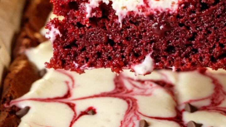 Red velvet cheesecake brownies with marbled swirls on a cooling rack