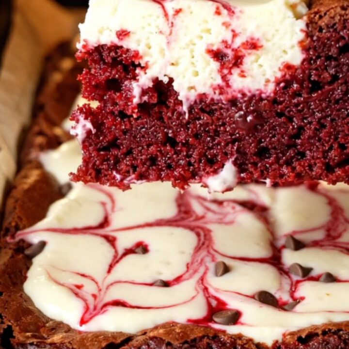 Red velvet cheesecake brownies with marbled swirls on a cooling rack