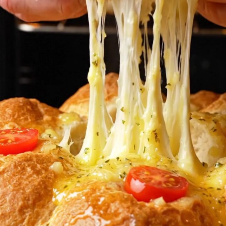 Pull-apart bread bites with golden crust and melted cheese stretching between them