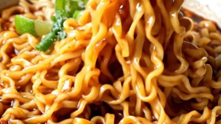 Glossy ramen noodles tossed in spicy garlic chili oil sauce with scallions and cilantro