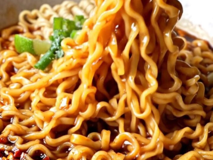 Glossy ramen noodles tossed in spicy garlic chili oil sauce with scallions and cilantro