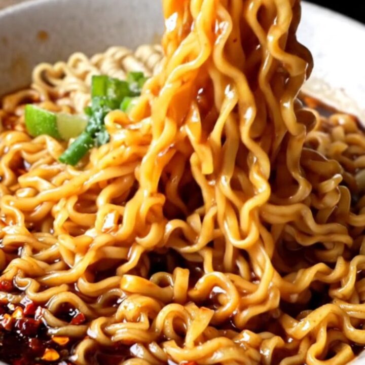 Glossy ramen noodles tossed in spicy garlic chili oil sauce with scallions and cilantro