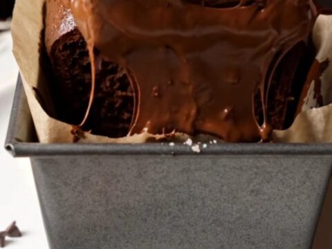 Sliced double chocolate banana bread with melted chocolate chips on a wooden board