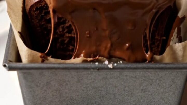 Sliced double chocolate banana bread with melted chocolate chips on a wooden board