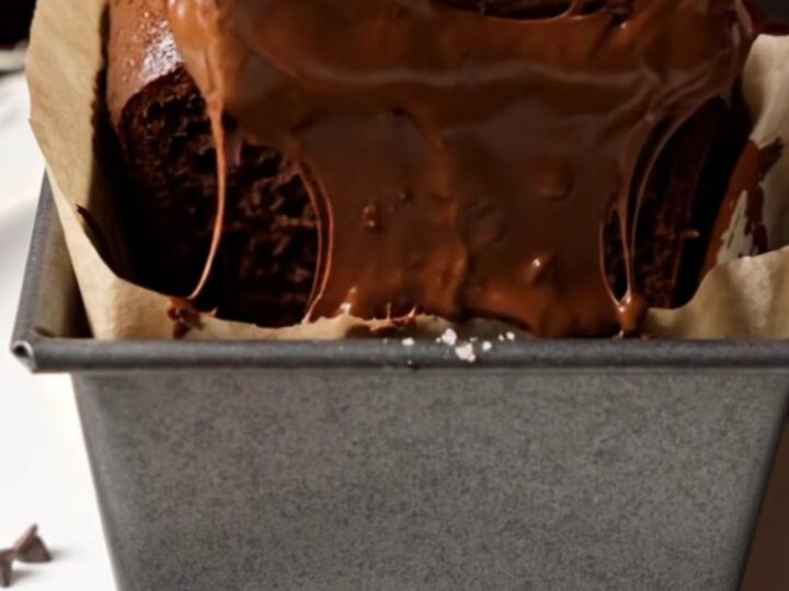 Sliced double chocolate banana bread with melted chocolate chips on a wooden board