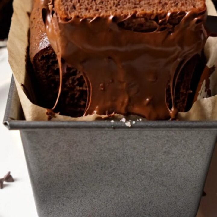 Sliced double chocolate banana bread with melted chocolate chips on a wooden board