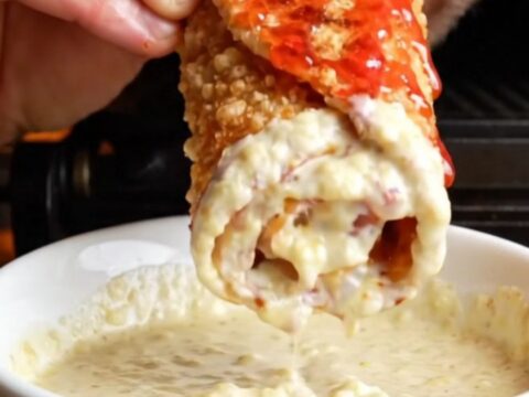 Crispy chicken shawarma wrap sliced diagonally showing chicken, fries, onions, and toum