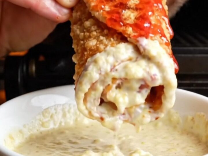 Crispy chicken shawarma wrap sliced diagonally showing chicken, fries, onions, and toum