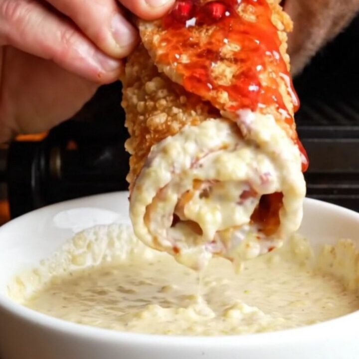 Crispy chicken shawarma wrap sliced diagonally showing chicken, fries, onions, and toum