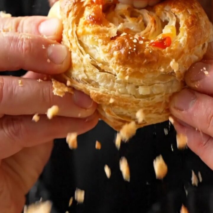 Golden puff pastry pizza flowers on a parchment-lined baking sheet