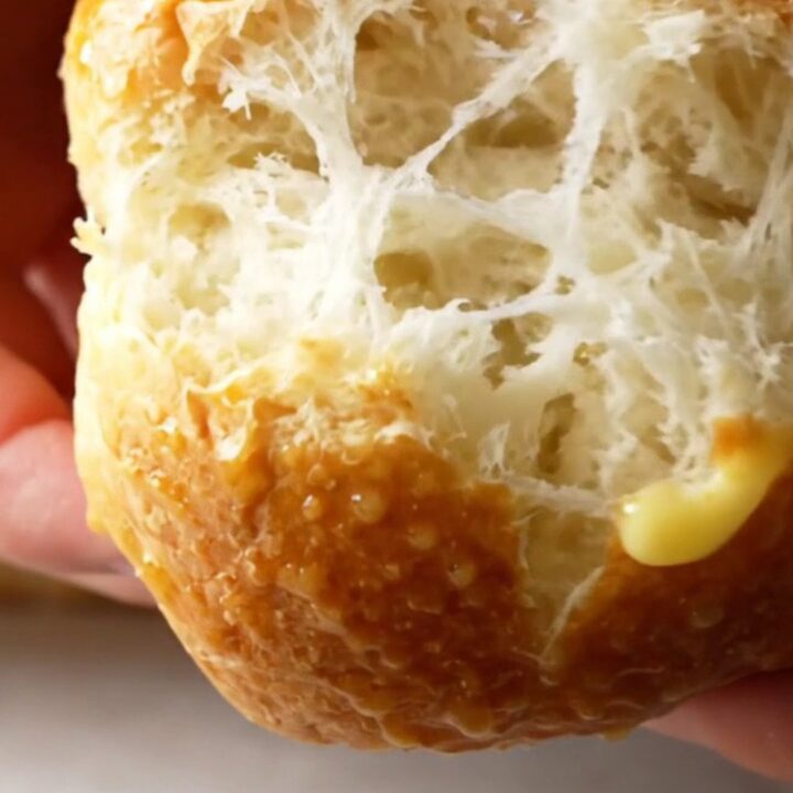 Golden brown homemade sandwich buns on a baking sheet, soft and pillowy