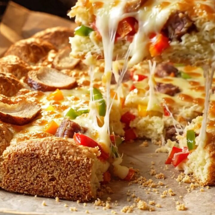 Golden Turkish sheet pan breakfast cake with melted cheese and sucuk slices, cut into squares.