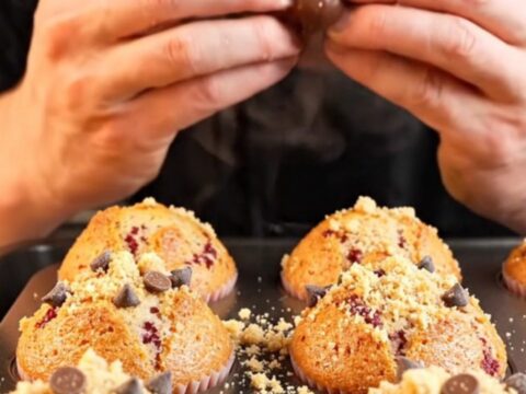 Golden raspberry chocolate chip crumble muffins on a cooling rack