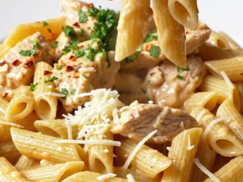 Creamy chili garlic chicken pasta in a skillet, garnished with parsley and chili flakes