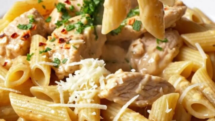 Creamy chili garlic chicken pasta in a skillet, garnished with parsley and chili flakes