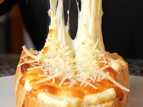 Golden pull-apart bread with melted mozzarella and parmesan on a baking sheet