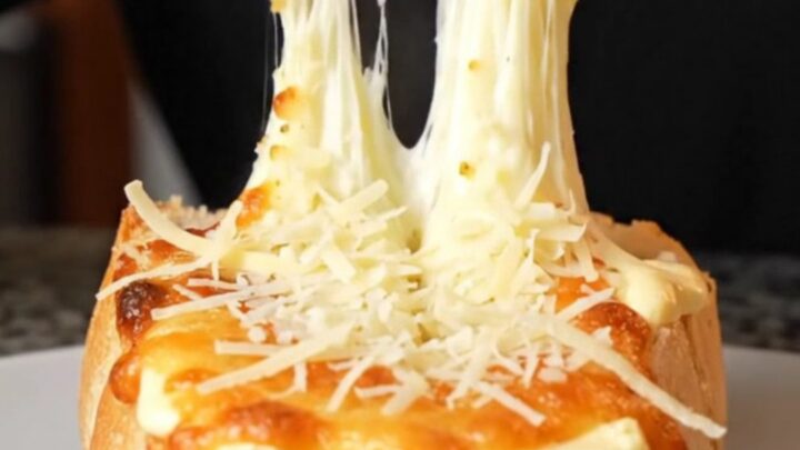Golden pull-apart bread with melted mozzarella and parmesan on a baking sheet