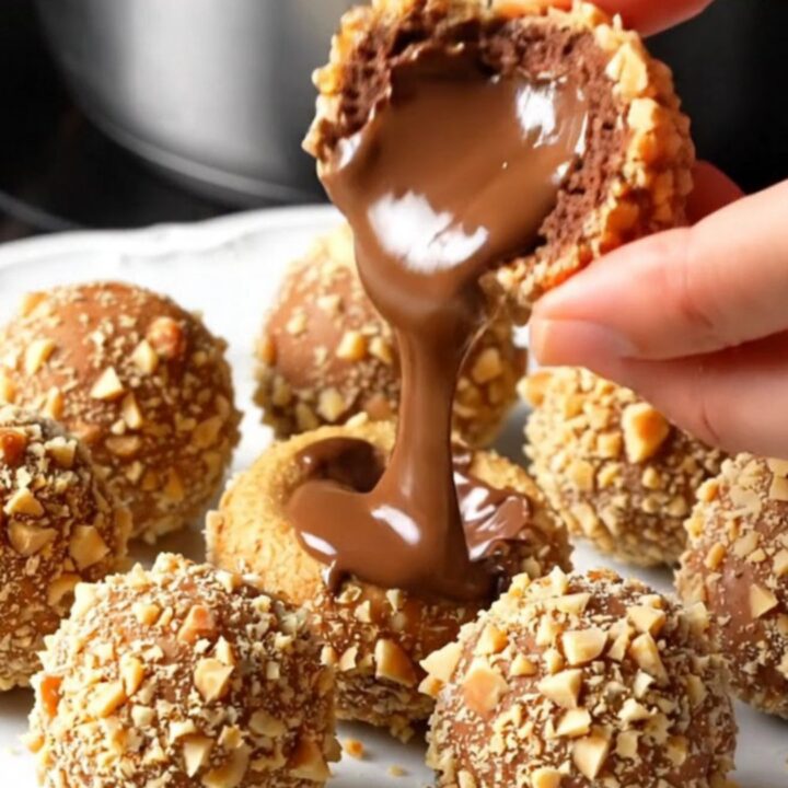 A truffle sliced in half showing molten Nutella center on a plate