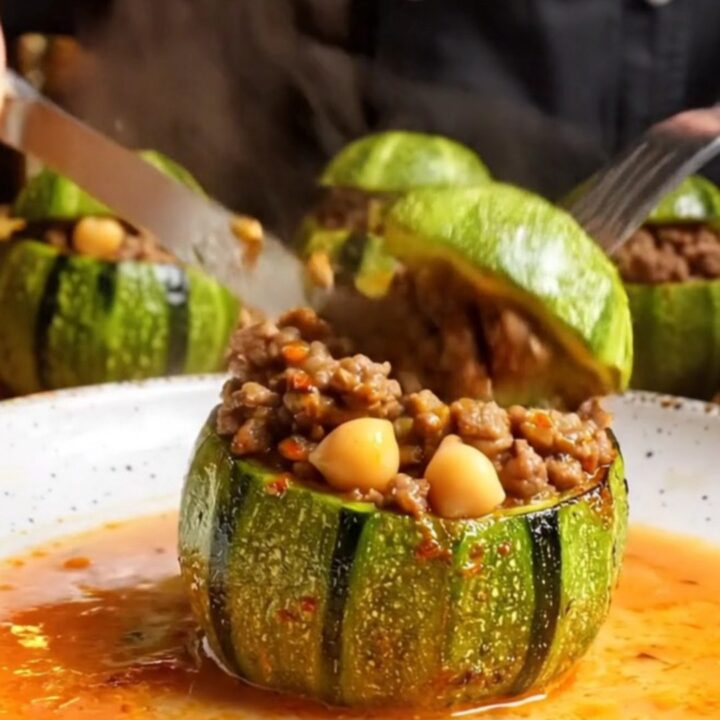 Tender stuffed round zucchini with beef and chickpea filling, cut open to show the savory interior